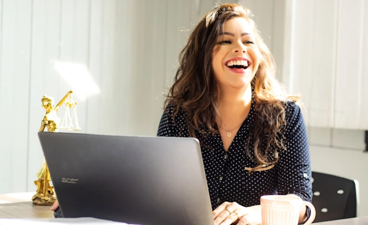 femme riant devant son laptop